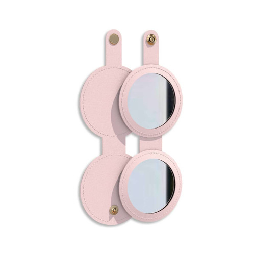 A round folding pocket mirror in a soft pink casing, featuring a logo on the front and two mirrored surfaces.