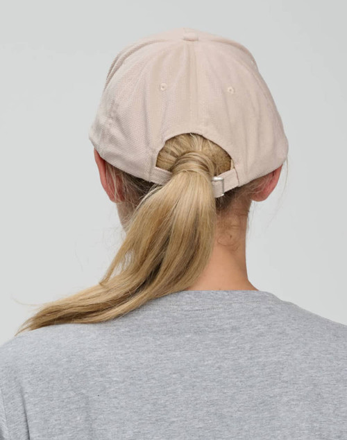 A light beige cap with a five-panel design, featuring an adjustable strap at the back.