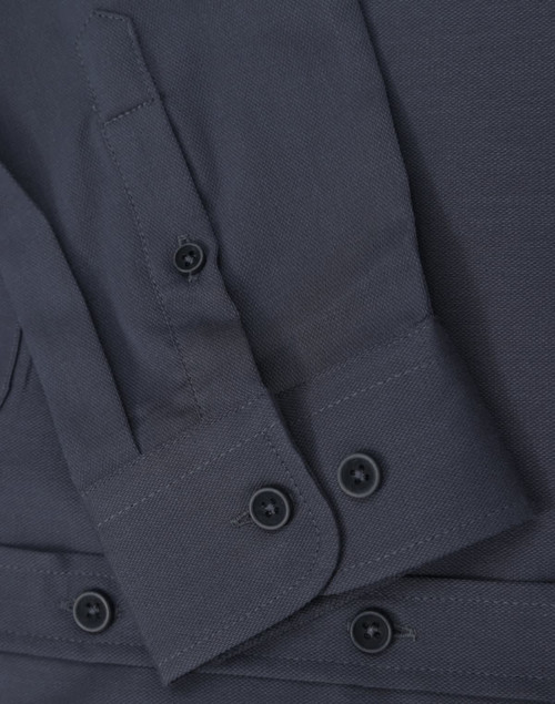 A dark grey ladies' long-sleeve shirt featuring buttoned cuffs and a smooth fabric texture. It has a logo present.