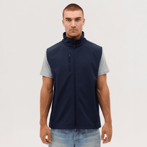 A navy softshell vest is worn over a grey short-sleeved shirt, featuring a zip closure and a pocket.