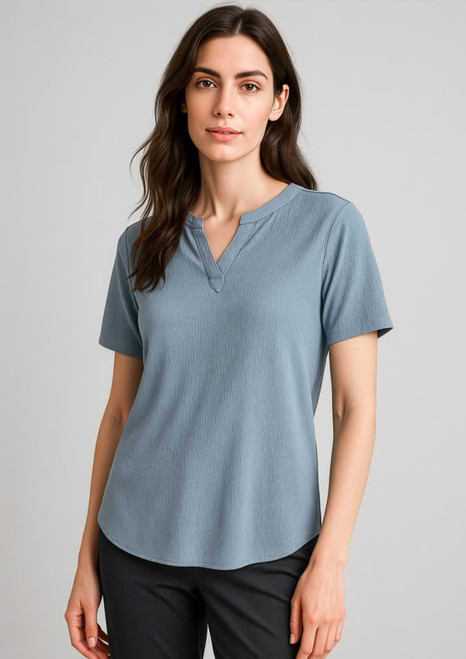 A women's short sleeve blouse in a light blue hue, featuring a henley-style neckline and a relaxed fit.