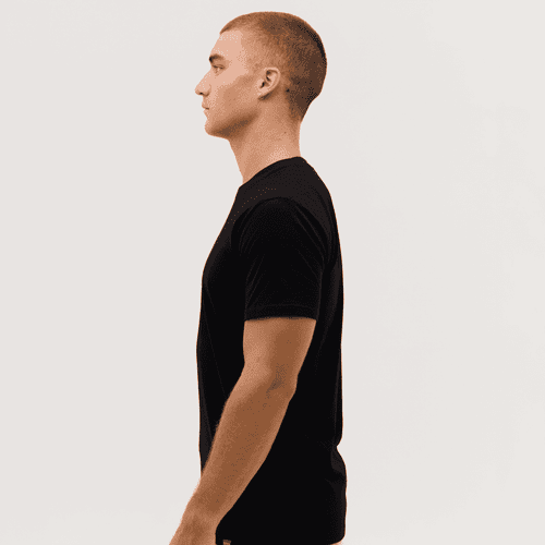 A black t-shirt is displayed on a model, shown from the side profile against a plain background.