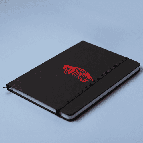 A black A5 notebook with a logo on the cover and an elastic closure, set against a light blue background.