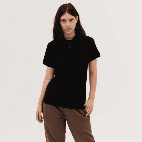 A black women's polo shirt displayed on a model, featuring a collar and short sleeves. The shirt has a branding logo.