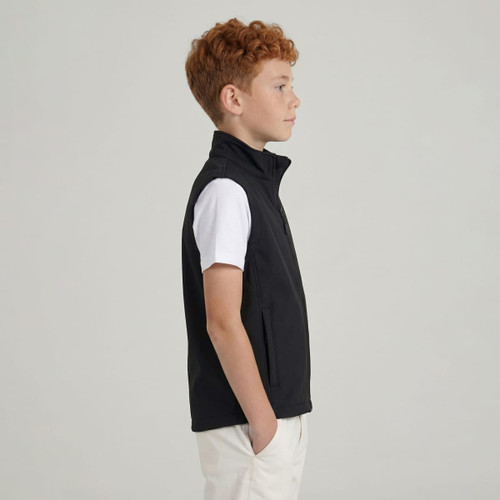 A softshell vest in black worn by a child with red curly hair, featuring a zip and a side view.