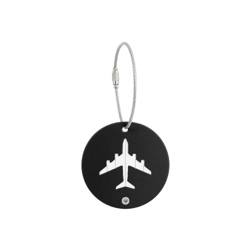 A round black luggage tag featuring a white airplane design, attached with a silver wire cable.