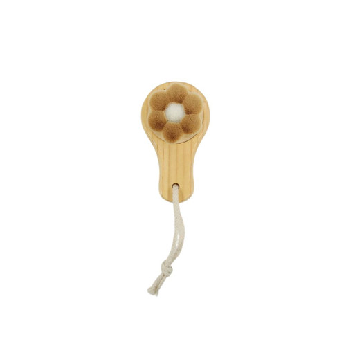 A flower-shaped facial cleansing brush with a wooden handle and cream-coloured bristles, featuring a hanging rope.