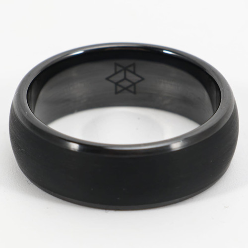 A black carbon fibre ring with a smooth finish and an engraved design on the interior.