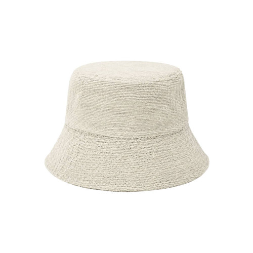 A dual-material reversible bucket hat in a light beige colour with a textured finish. It features a logo.