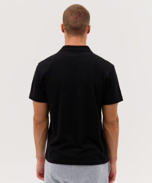 A black polo shirt with a simple design, viewed from the back, featuring short sleeves and a collar.