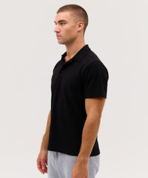 A black polo shirt displayed on a model, featuring a simple design and a classic collar.