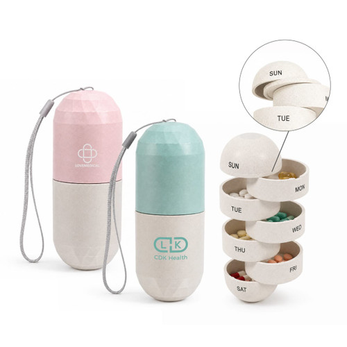 A capsule-shaped pills organiser in pink and green, featuring separate compartments for each day of the week.