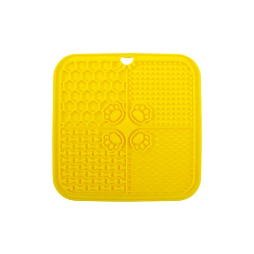 A yellow, four-section silicone lick mat featuring textured patterns and paw prints, with a hole for hanging.