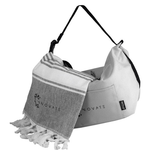 A towel with tassels and a cooler bag in grey and white, featuring a logo on both items.