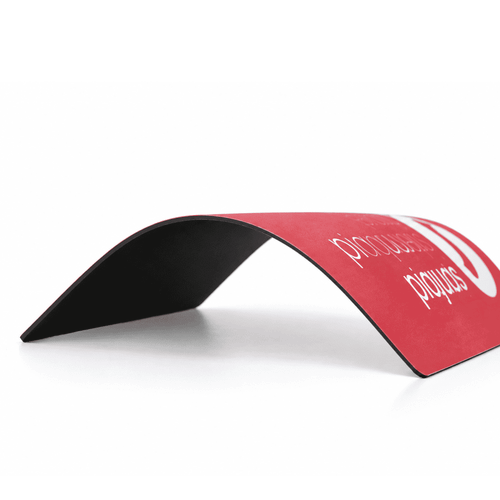 A red mouse mat with a natural rubber base. It features a slight curve and has a logo on the surface.