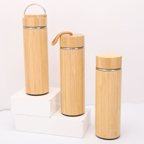 A drink bottle trio in natural bamboo finish, featuring metal accents and various styles, displayed on a white platform.