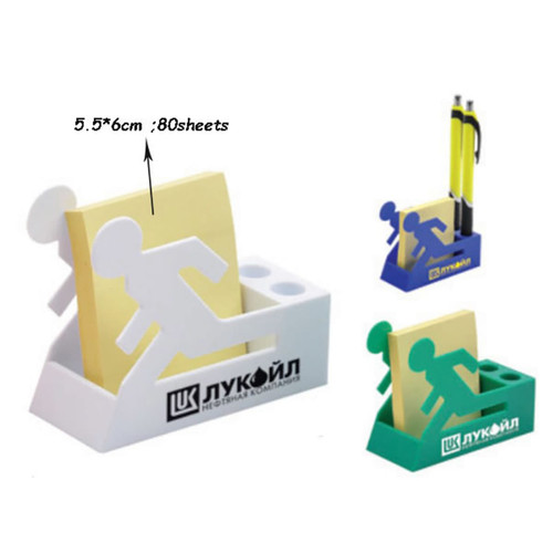 A white and green pen holder with a memo pad, featuring a figure design, holds pens and sticky notes.