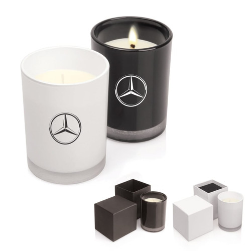 A set of two scented candles in white and black glass containers, both featuring a logo.