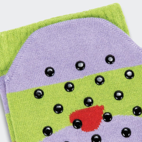 A pair of purple and green grip socks featuring black dots and a red accent, with a logo on one side.