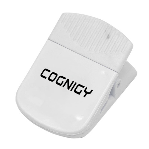 A white magnetic clip with a textured grip and a logo, designed for holding papers or other items.
