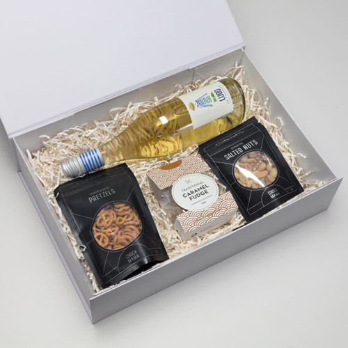 A drink bottle, black snack bags of pretzels and salted nuts, and a caramel fudge treat in a white gift box.