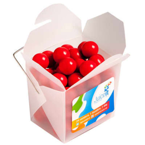 A frosted noodle box containing round orange chocolate drops, with a handle and a colourful logo.