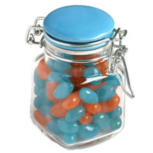 A glass clip lock jar with a blue lid, filled with blue and orange mini jelly beans.