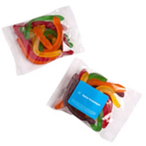 A clear bag filled with coloured gummy snakes in vibrant green, orange, red, and yellow hues. The bag features a logo.