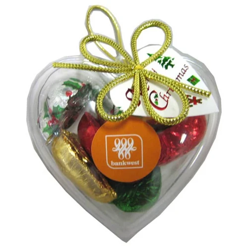 Acrylic heart-shaped container filled with assorted Christmas chocolates, featuring red, green, gold, and silver foiling.