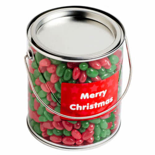 A metal bucket filled with red and green jelly beans, featuring a Christmas-themed label.