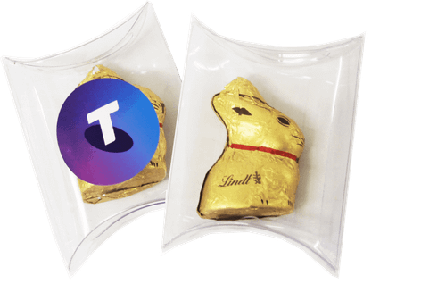 A clear pillow pack containing a gold 10g Lindt Bunny with a logo on one side and the bunny visible on the other.