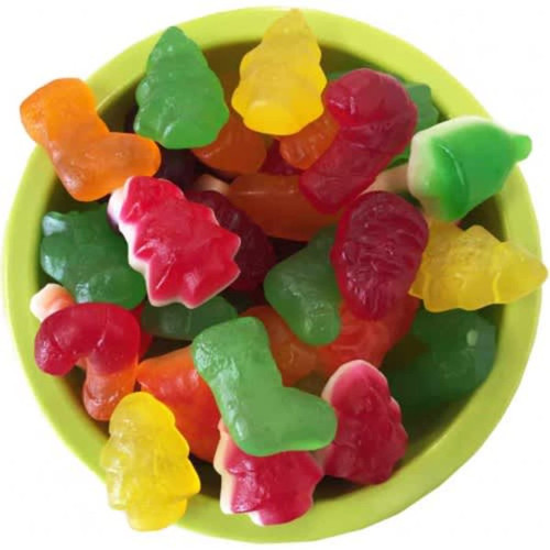 A bowl filled with colourful mixed lollies in festive shapes like trees and boots, featuring red, green, yellow, and orange.