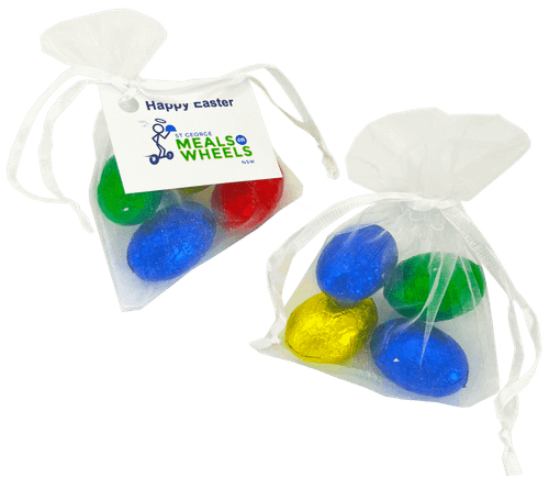 Organza bags containing four mini solid Easter eggs in blue, green, and gold. Each bag is tied with a white ribbon.