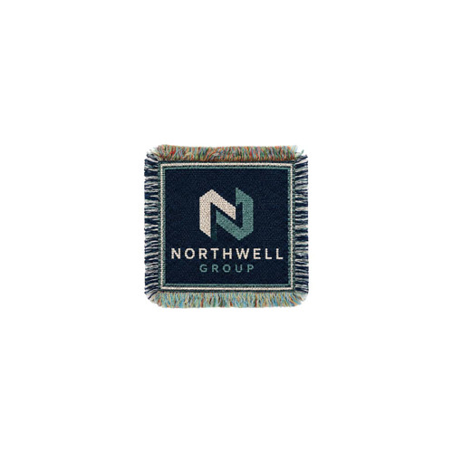 A jacquard coaster in navy blue with a woven logo and fringe detailing around the edges.
