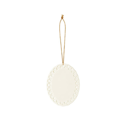 A ceramic ornament in white with a decorative lace-like edge and a gold hanging string.