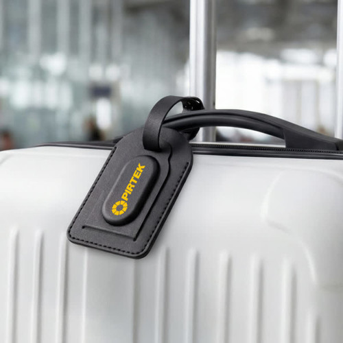 A black luggage tag attached to a white suitcase, featuring a logo on its surface.