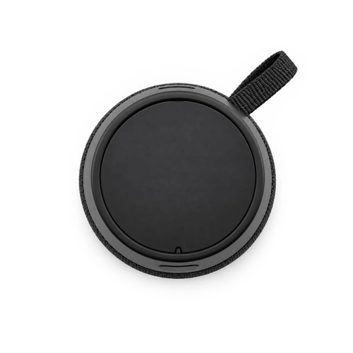 A round black speaker with a textured fabric edge and a loop for attachment. It has a smooth, flat surface on top.
