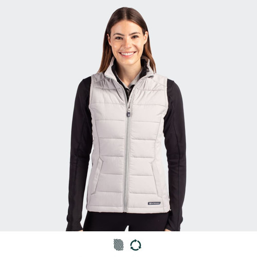 A woman is wearing a light grey, sleeveless hybrid vest with a zip front, featuring a branding logo.