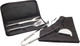 A BBQ tool and apron set in black, featuring a spatula, tongs, and a grill fork in a carrying case.