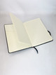 An A5 notebook with 240 lined pages, featuring a black cover and a ribbon bookmark. It has a built-in pocket.