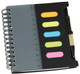 A black spiral notebook with a ruler, a pen, and four sticky note flags in neon colours.