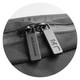 A zip detail of a black Moleskine Metro Slim Backpack featuring dual zippers and a textured surface.