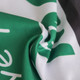 A close-up of a green and white polyester scarf featuring a logo, highlighting its texture and fabric.