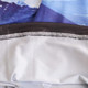 An Ice Silk Neck Gaiter featuring a mountain print in shades of blue and grey, with a smooth, elastic edge.
