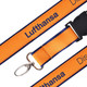 A detailed woven lanyard in orange and navy, featuring a clip and a branding logo.