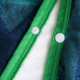 A flannel blanket featuring a green edge with buttons, showcasing soft textures in shades of blue and white.