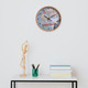 A round wall clock with a wood grain frame, featuring a map design and a logo, displayed on a stylish table.