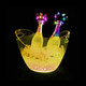 An 8L LED ice bucket in transparent yellow, holding two champagne bottles surrounded by ice and lit with colourful lights.