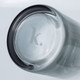 A glass carafe with a dark rim and a logo at the base, showcasing a sleek and modern design.