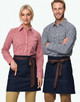 Denim half aprons in dark blue featuring brown ties, displayed on a male and female model wearing checkered shirts.